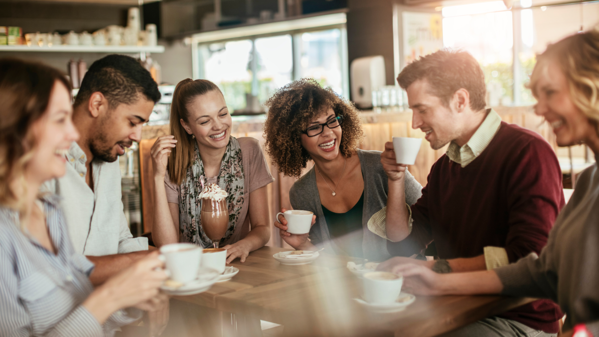 A group of diverse young professionals meeting together at a coffee shop.